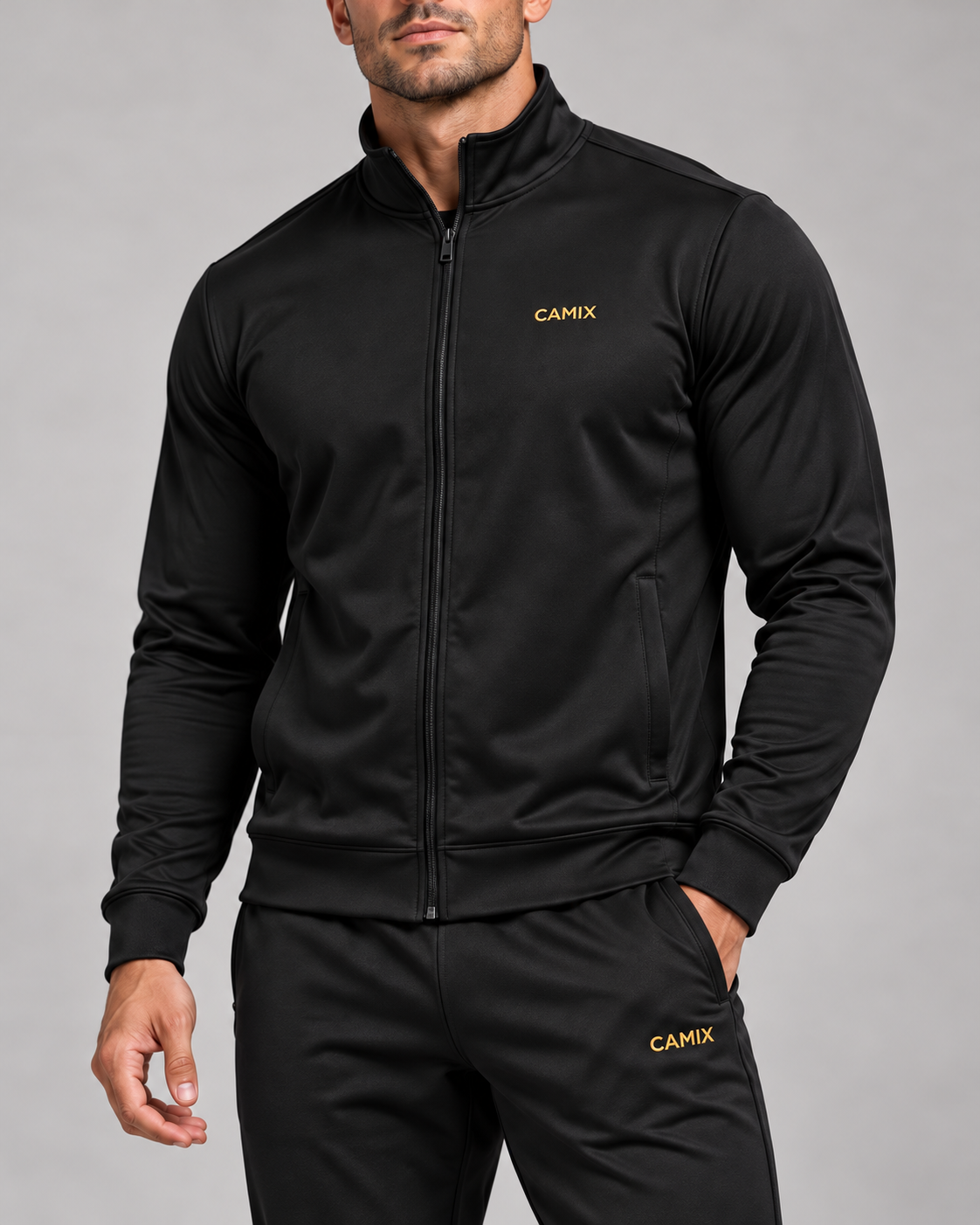 Detail van de gouden CAMIX-logo's op het zwarte heren trainingspak